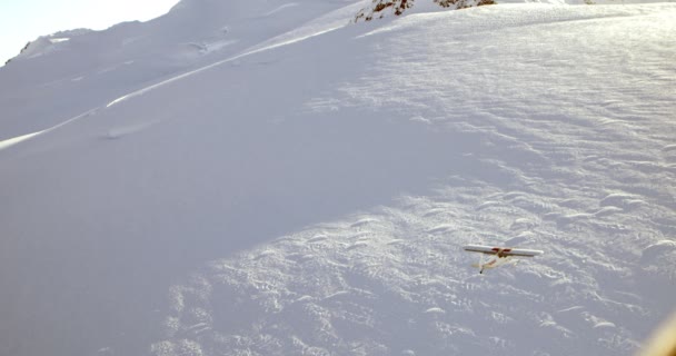 Aerial Follow Маленький Самолет Летящий Над Снежным Полем — стоковое видео