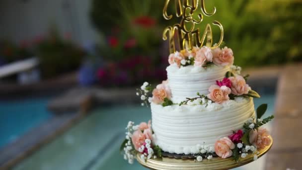在一个夏天的婚礼招待会上 一个装饰精美的花卉婚礼蛋糕坐在游泳池旁边的底座上 被枪杀了 — 图库视频影像
