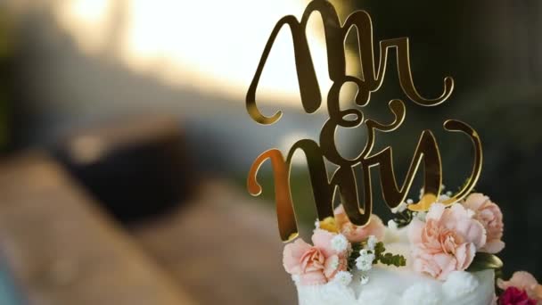 夏の結婚式のレセプション中にプールのすぐ隣の台座に座って美しく装飾された花のウェディングケーキのショット — ストック動画