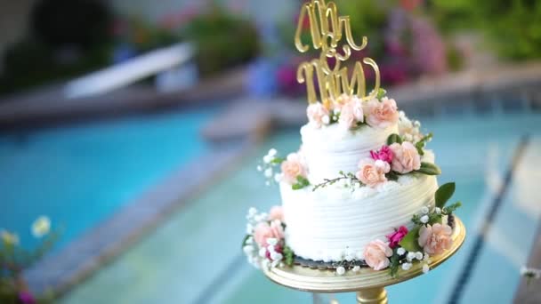 Съемка Красиво Украшенного Цветочного Свадебного Торта Сидящего Пьедестале Рядом Бассейном — стоковое видео