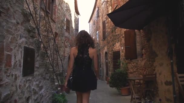 Молодая Брюнетка Черном Платье Идет Через Маленькую Средневековую Итальянскую Деревню — стоковое видео
