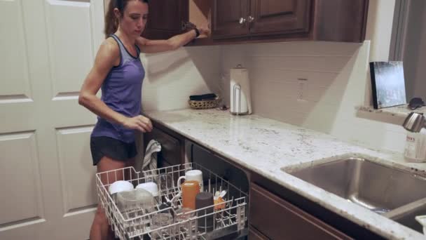Perempuan Membongkar Barang Pecah Belah Dan Piring Dari Mesin Cuci — Stok Video