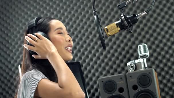 アジアの10代の女性は マイクコンデンサや機器をぶら下げて 大きな声で歌を歌う黒い長い髪を包んだ 卵クレートスタジオ低照明影防音壁の部屋を吸収 — ストック動画
