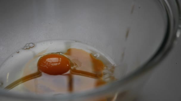将牛奶倒入装有蛋黄和油的大玻璃碗中的慢动作 — 图库视频影像