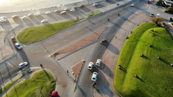 モンテビデオに位置する晴れた日に公園を介して海岸沿いの交通と道路上の白い車の空中ビデオウルグアイ — ストック動画