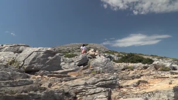 女孩缓慢地爬上岩石山的向上基座 — 图库视频影像
