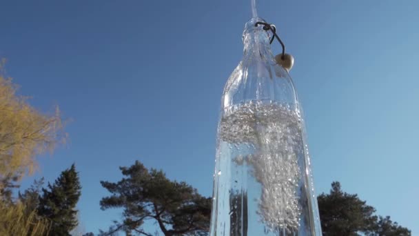 Gießen Von Wasser Glasflasche Mit Blauem Himmel Und Baum Hintergrund — Stockvideo