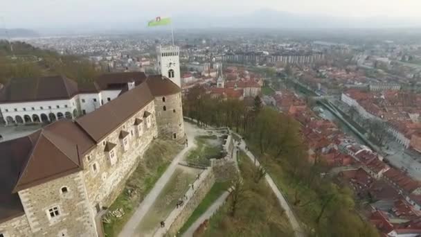 街の最も重要なランドマークの一つであるリュブリャナ城と旗を飛び越える スロベニア — ストック動画