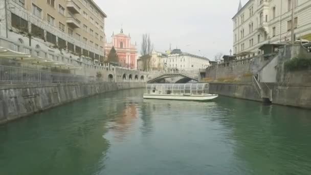 スロベニアのリュブリャナのLjubljanica川を渡る通常のルートでの小さな観光船クルーズ — ストック動画