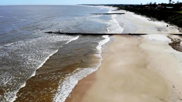日当たりの良い日には 防波堤や人々が釣りをするビーチの空中ビデオ フロレスタ ウルグアイ — ストック動画