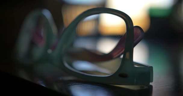Ciemne Ujęcie Niebiesko Fioletowej Pary Okularów Stole Nieostrym Oknem Tle — Wideo stockowe