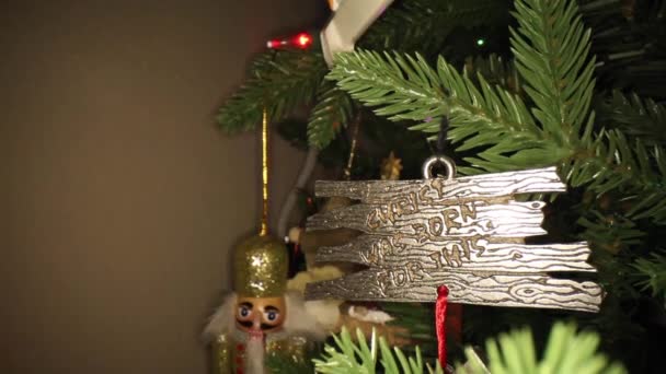 金属製のクリスマスツリーの飾りに向かってゆっくりと押すと キリストはこれのために生まれました 背景にはくるみ割り人形とマネージャーの飾りがあります 金属とレタリングの極端な閉鎖で仕上げ — ストック動画