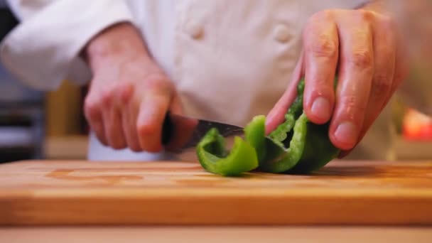 Cozinheiro Corta Pimenta Verde Uma Tábua Madeira — Vídeo de Stock