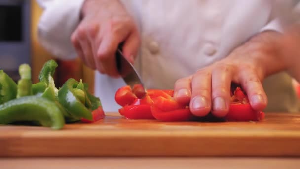 Cozinheiro Corta Pimenta Vermelha Uma Tábua Madeira — Vídeo de Stock