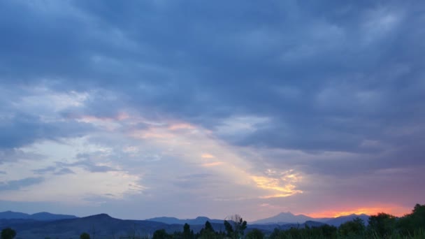遠くに岩の多い山と緑のフィールド上の青い雲と夕日のショットを確立極端なワイド — ストック動画
