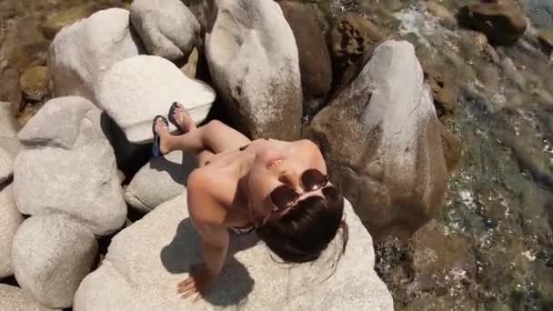 Bikini Genç Kadın Kayalık Sahilde Güneşleniyor Gülümsüyor — Stok video