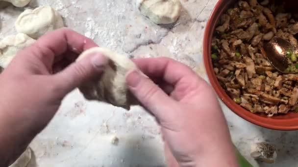 生地を作って伸ばして肉を詰め込むことで蒸しパンを作る — ストック動画