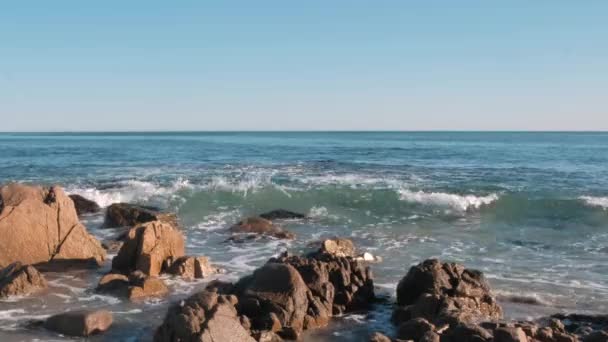 Olas Rompiendo Suavemente Sobre Rocas Océano Con Ballenas Saltando Distante — Vídeo de stock