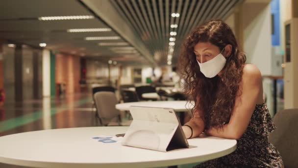 Yüz Maskeli Genç Kız Kamu Alanında Masa Başında Oturmakta Tablet — Stok video