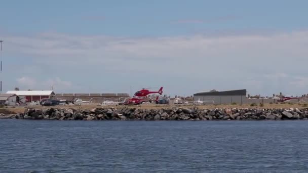 Röd Helikopter Landar Robben Island Helikopter Flyg Inspelning Från Katamaran — Stockvideo