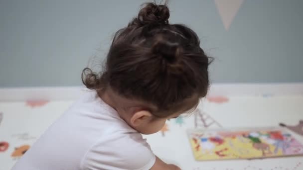 Крупним Планом Малюк Перетворює Сторінки Ілюстрованої Дитячої Книги Сидячи Підлозі — стокове відео