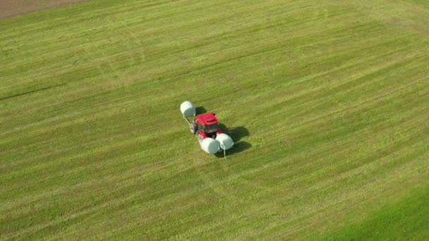 Vörös Traktor Felvette Bálák Zöld Rét Mezőgazdasági Mezőgazdasági Koncepció Légi — Stock videók