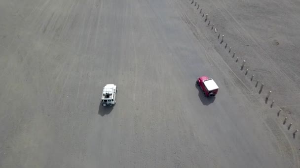 オフロード車不毛のほこりだらけのブロモ火山壮大な風景に乗って 東ジャワ州 インドネシア 空中フライオーバー追跡ショット — ストック動画