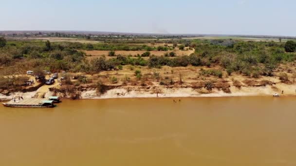 車でマダガスカルのトリビヒナ川を横断する川のフェリーに乗るのを待つ 空中ビュードローンワイドショット — ストック動画