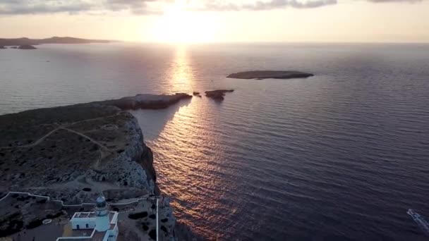美しい夕日と灯台スペイン バレアレス諸島 メノルカ島の北海岸のカヴァレリア岬 空中プルバック — ストック動画