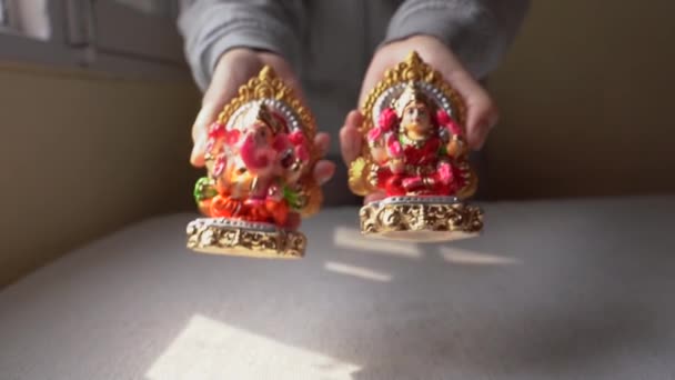 展示印度教领主甘尼沙和女神拉斯米五彩斑斓的粘土偶像的手 在Diwali 也就是光之节 人们崇拜的印度神 — 图库视频影像