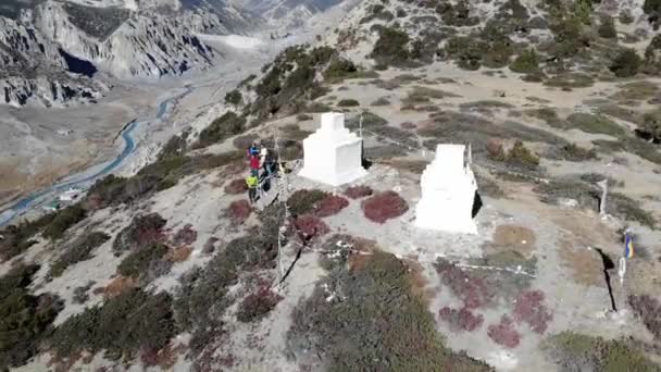 游客们站在尼泊尔安娜普纳环路旅行的一座山顶上 靠近两个带着祈祷旗的小古塔 空中驾驶员轮转射击 — 图库视频影像