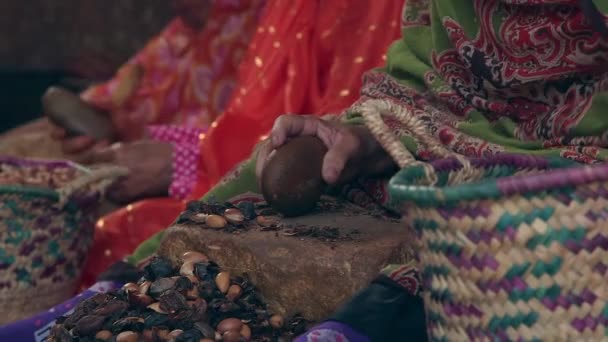 多くの女性の手は夕食のために石でアーガンの種子と豆を粉砕 — ストック動画