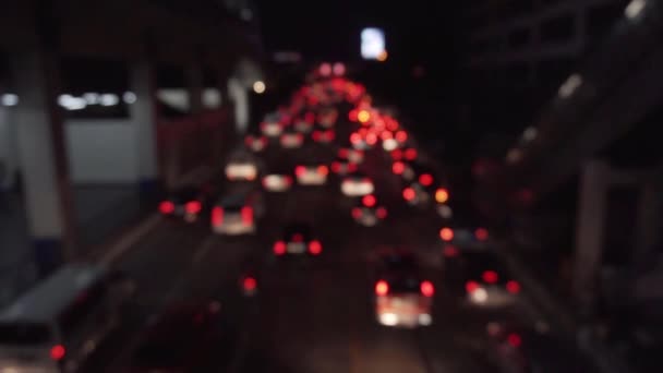 トラフィック内の赤いボケ車のライト 夜のロードショット — ストック動画