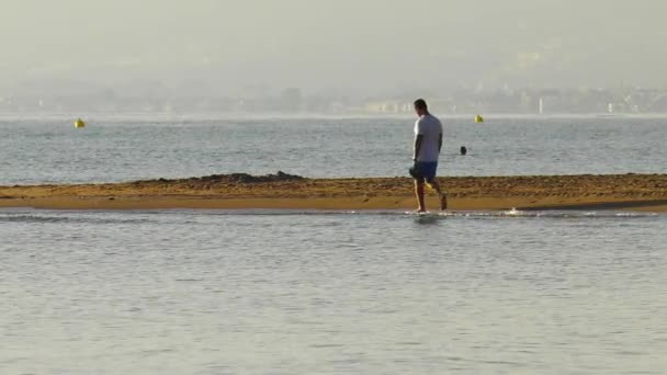 젊은이는 해변의 모래사장을 맨발로 걸으며 천천히 — 비디오