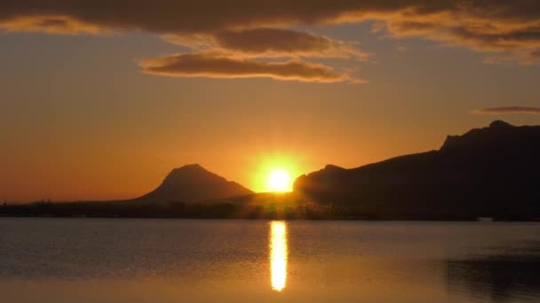 穏やかな湖を反映して山の上の日の出 ズームアウト — ストック動画