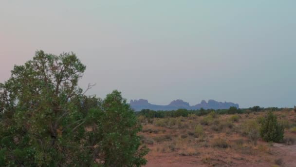 Verbazingwekkende Berg Rotsformaties Zitten Aan Horizon Achter Struiken Bomen Moab — Stockvideo