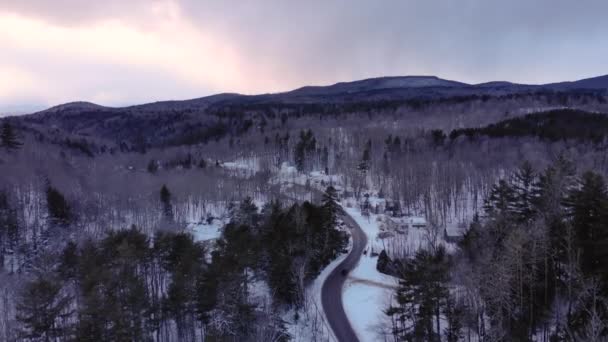 日没時のバーモント州の雪山の小さな道を横断する車 — ストック動画