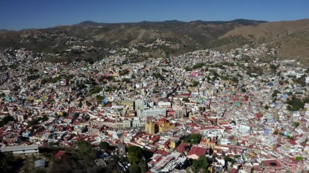 中央のサンタ プリスカ教区教会の空中ドローン回転ショット昼は山脈に囲まれたメキシコ ゲレロ州のタクシー アルコン市 — ストック動画