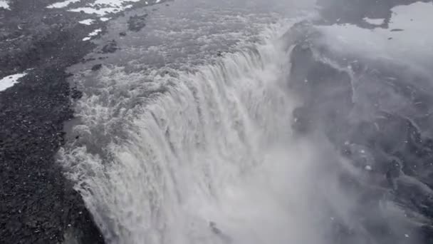 冬のアイスランドの強力な防潮堤 吹雪の中での高角度ドローンの眺め — ストック動画