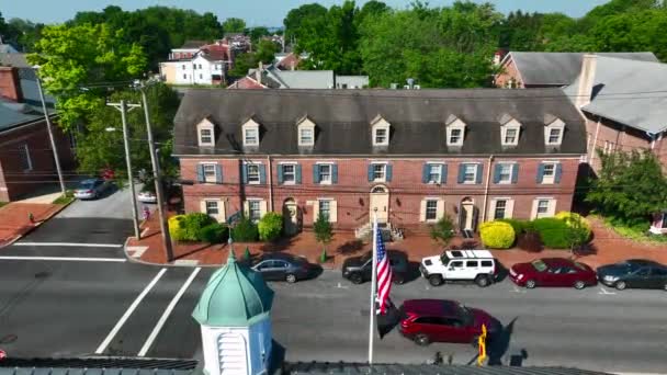벽돌로 미국의 아파트 건물이다 여름에는 마을에 국기가 차들은 거리를 지나간다 — 비디오