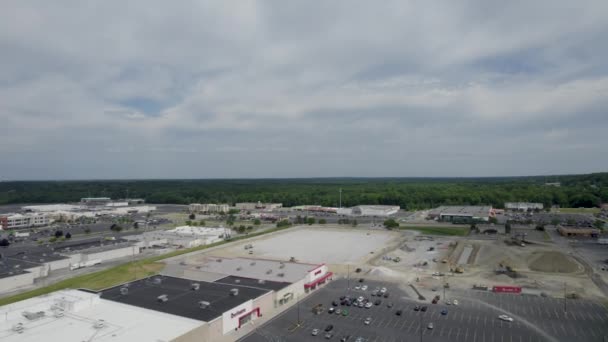 建筑工地附近设有车辆及空置泊车位的商场空中俯瞰 — 图库视频影像