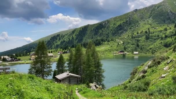 集落に囲まれた渓谷には 透き通った青い湖が広がっています 背景に高い山のピーク ハイキング — ストック動画