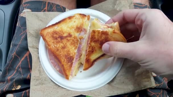 Seseorang Makan Roti Lapis Ham Dan Keju Cepat Saji Panggang — Stok Video