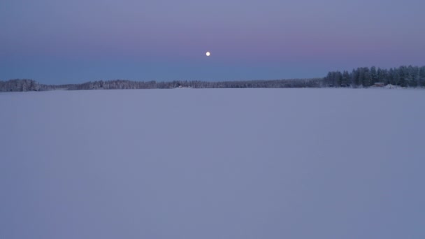 空中的月亮在冰冻的斯堪的纳维亚雪地上闪闪发光 — 图库视频影像