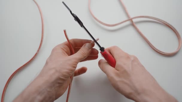 男人用钢丝剥脱工具剥除两根电线 — 图库视频影像