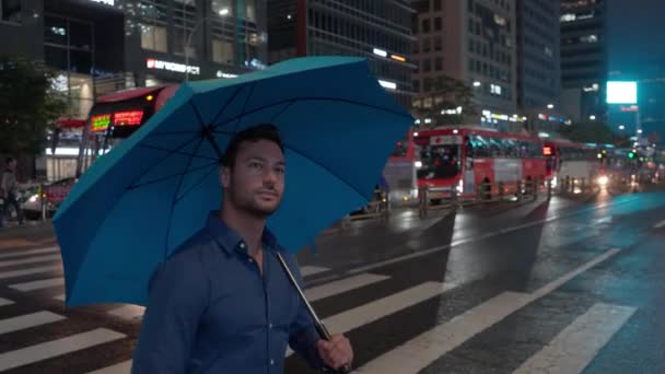 在繁忙的首尔市的斑马线上 一个男人带着雨伞十字街 追踪镜头 — 图库视频影像