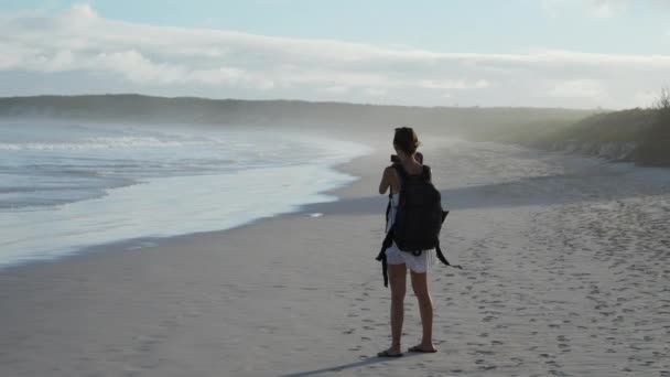 年轻的女背包客在加拉帕戈斯的Tortuga湾拍摄海浪的照片 慢动作 — 图库视频影像