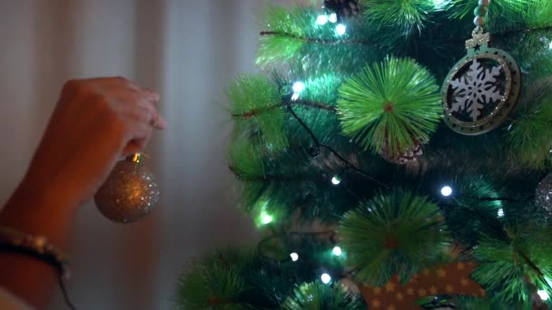 Close Van Hand Van Een Meisje Plaatst Een Kerstbal Kerstboom — Stockvideo