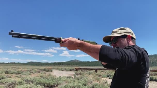 男性銃愛好家は砂漠の射撃範囲で金のトリムレバーアクションライフルを発射し 台座ショット — ストック動画