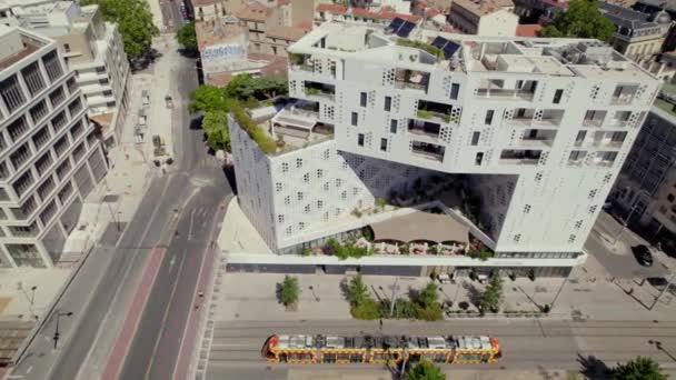 一辆五颜六色的电车驶向一座漂亮的公寓楼前 — 图库视频影像